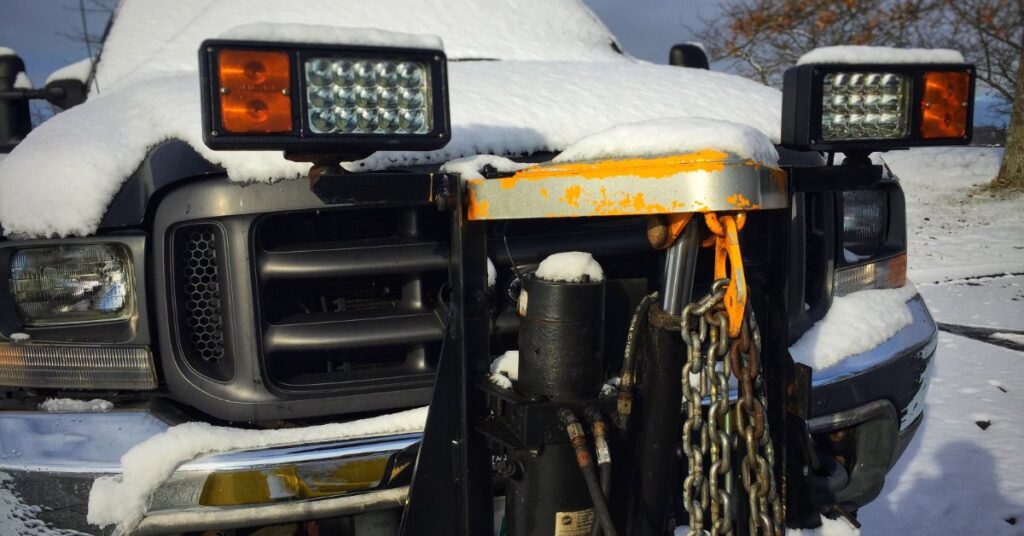 a snow-covered pickup truck front with a rectangular LED light bar mounted above the windshield outdoors.