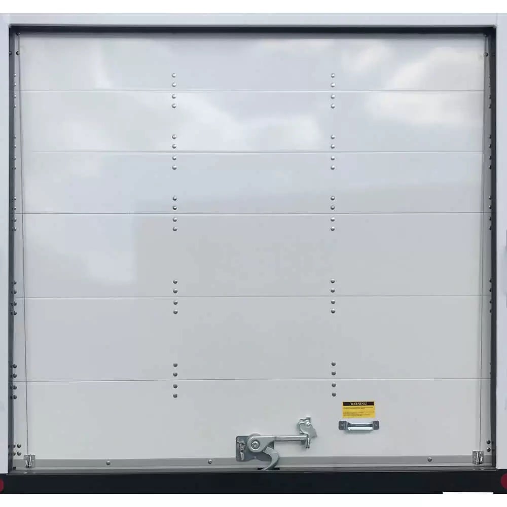 The rear of a white stepvan has a closed roll-up door between round side lights and a black step bumper below.